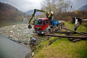 vyťahovanie odpadu hydraulickým ramenom z vodnej nádrže