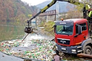 vyťahovanie odpadu hydraulickým ramenom z vodnej nádrže