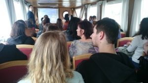 ľudia pučúvajú prednášku na lodi
