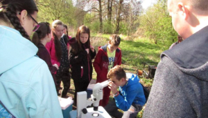 študenti si prezerajú vzorky vody pod mikroskopom